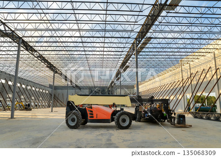 Construction site of logistic center with assembling of concrete and metal frame walls. Aerial view of large development area of commercial structure 135068309
