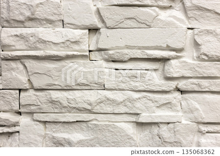 Close-up of white solid limestone wall or stone fence. Abstract copy space background, Bricklaying, construction and masonry concept. 135068362
