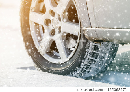 Close-up of car wheels rubber tires in deep winter snow. Transportation and safety concept. Close-up of car wheels rubber tires in deep winter snow. Transportation and safety concept. 135068371