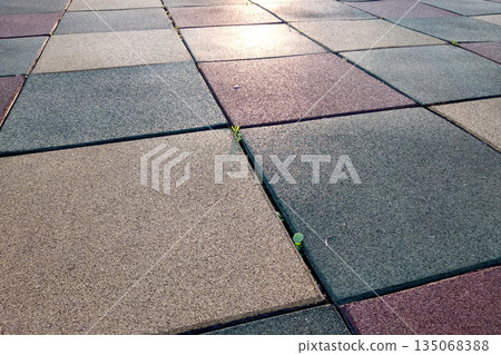 Close up of soft rubber tiles for covering at outdoor gym of stadium at preschool yard. Close up of soft rubber tiles for covering at outdoor gym of stadium at preschool yard. 135068388