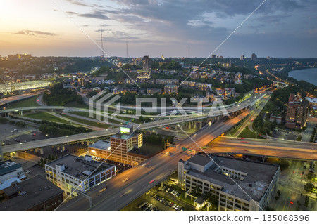 Cincinnati, Ohio transportation infrastructure. View from above of American big freeway intersection at night with fast moving cars Cincinnati, Ohio transportation infrastructure. View from above of American big freeway intersection at night with fast moving cars 135068396