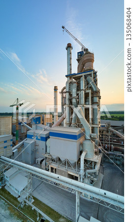 Cement plant with high factory structure and tower cranes at industrial production area. Manufacture, global industry and air pollution concept 135068404