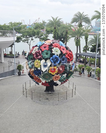 A vibrant floral sphere sculpture anchors a waterfront plaza 135070094