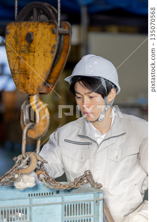 工人在進行高架起重機和吊運作業 工人在進行高架起重機和吊運作業 135070568