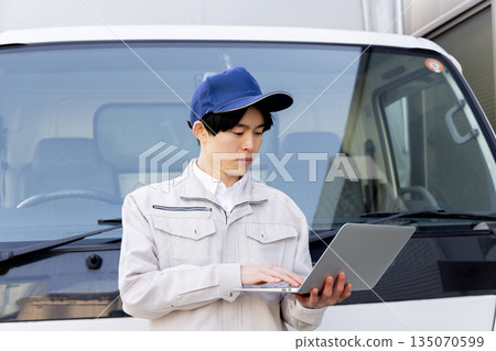 Delivery staff using laptop in truck Delivery staff using laptop in truck 135070599