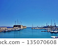 A view of the harbor of Heraklion, Crete, Greece, with ships in the foreground and the cityscape in the background 135070608