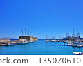 A view of the harbor of Heraklion, Crete, Greece, with ships in the foreground and the cityscape in the background 135070610