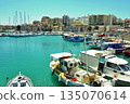 A view of the harbor of Heraklion, Crete, Greece, with ships in the foreground and the cityscape in the background 135070614