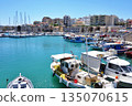 A view of the harbor of Heraklion, Crete, Greece, with ships in the foreground and the cityscape in the background 135070615