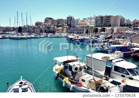 A view of the harbor of Heraklion, Crete, Greece, with ships in the foreground and the cityscape in the background 135070616