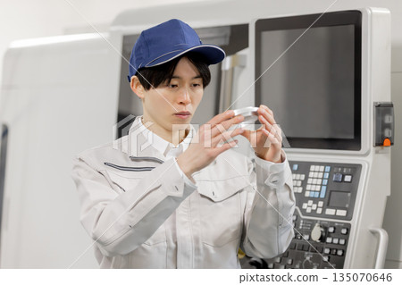 一名男工人在工廠檢查車床加工和銑削的產品 135070646