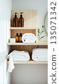 Spa treatment set, wooden shelf with neatly folded towels and dispensers for soap, cream, massage oil 135071342