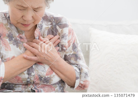Image of a senior woman in poor health with chest and heart pain. Myocardial infarction? Intercostal neuralgia? Angina? Image of a senior woman in poor health with chest and heart pain. Myocardial infarction? Intercostal neuralgia? Angina? 135071479