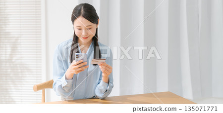 Woman holding a smartphone and a credit card (banner) Woman holding a smartphone and a credit card (banner) 135071771