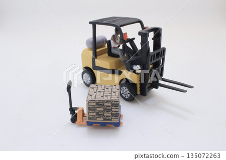 Miniature Toy Forklift With Driver Moving Box Pallet In Warehouse 135072263