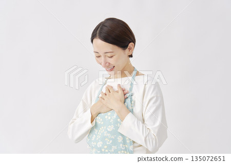 身穿圍裙的女子，神情如釋重負，白色背景 135072651