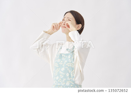 白色背景上的哭泣女子，穿著圍裙 135072652