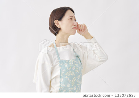 白色背景上的哭泣女子，穿著圍裙 135072653