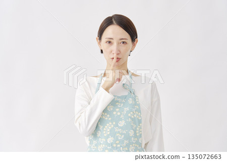 身穿圍裙的女子，神秘手勢，白色背景 135072663