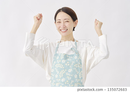 身穿圍裙的女子，握拳，白色背景 135072683