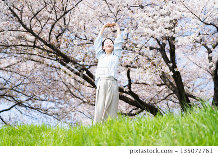 年輕女子在櫻桃樹下伸展身體 生活方式圖像 135072761