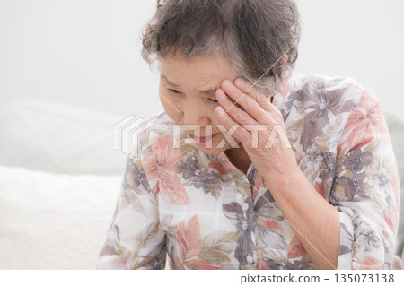Close-up image of senior elderly woman suffering from headache, feeling unwell, forgetfulness, etc. 135073138