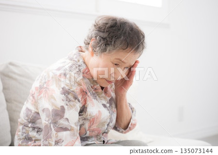 一張老年婦女的特寫鏡頭，她頭痛、感覺不適、健忘等等。 135073144