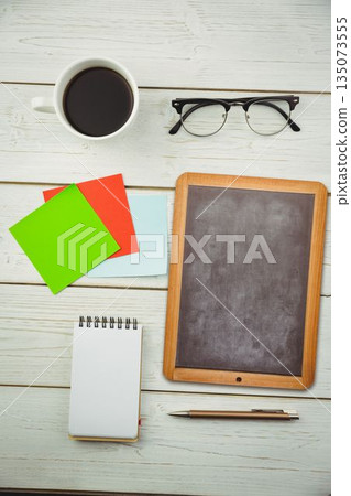Flat design workspace is showing coffee cup, glasses, sticky notes, chalkboard on painted tabletop Flat design workspace is showing coffee cup, glasses, sticky notes, chalkboard on painted tabletop 135073555