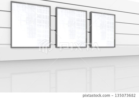 Gallery is showing flat white walls with horizontal rails and three blank frames on glossy floor 135073682