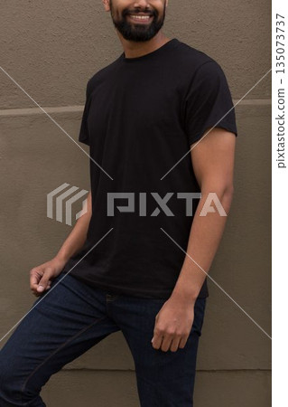 Adult Middle Eastern man leaning against light brown textured wall in flat design style, smiling 135073737