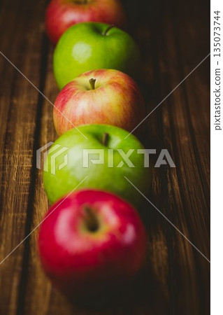 Red and green apples on table Red and green apples on table 135073744
