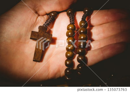 Hand holding rosary beads 135073763