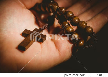 Hand holding rosary beads 135073838
