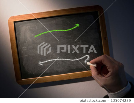 Hand drawing arrows on chalkboard 135074289