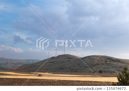 Türkiye rural landscape with tractor and wind turbines 135074672