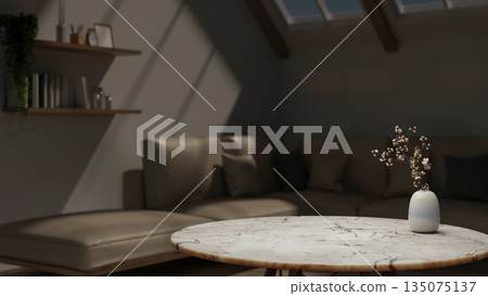 Flower vase on round marble table across leather sofa couch under roof window in dim attic living room. 135075137