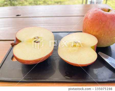 一個切成兩半的紅蘋果。 一個切成兩半的紅蘋果。 135075198
