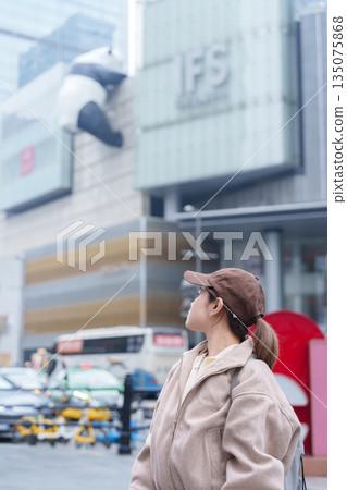 woman traveler travel in Chengdu city. Happy Tourist sightseeing in Chunxi Road, located in the Jinjiang District. Famous landmark for tourism attraction in Sichuan, China woman traveler travel in Chengdu city. Happy Tourist sightseeing in Chunxi Road, located in the Jinjiang District. Famous landmark for tourism attraction in Sichuan, China 135075868