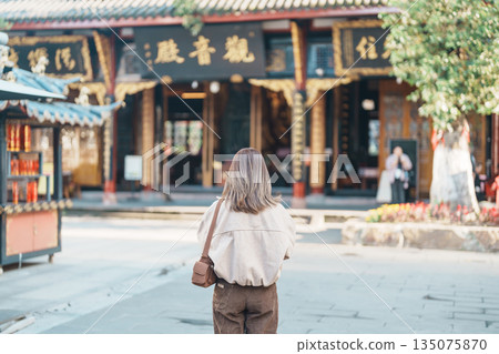 woman traveler travel in Chengdu city. Happy Tourist sightseeing in Daci Temple is a Buddhist temple . Famous Landmark for tourism attraction in Sichuan, China woman traveler travel in Chengdu city. Happy Tourist sightseeing in Daci Temple is a Buddhist temple . Famous Landmark for tourism attraction in Sichuan, China 135075870