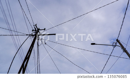 Electrical Power Lines and Street Light Against Overcast Sky 135076085