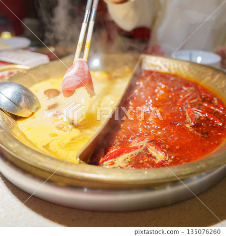 Woman tourist eating traditional hot pot or mala spicy soup in restaurant. Popular foods for tourist eating in Chengdu, Chongqing and China. Chinese Asia and Sichuan foods concept Woman tourist eating traditional hot pot or mala spicy soup in restaurant. Popular foods for tourist eating in Chengdu, Chongqing and China. Chinese Asia and Sichuan foods concept 135076260