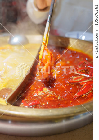 Woman tourist eating traditional hot pot or mala spicy soup in restaurant. Popular foods for tourist eating in Chengdu, Chongqing and China. Chinese Asia and Sichuan foods concept 135076261