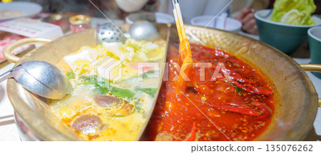 Woman tourist eating traditional hot pot or mala spicy soup in restaurant. Popular foods for tourist eating in Chengdu, Chongqing and China. Chinese Asia and Sichuan foods concept Woman tourist eating traditional hot pot or mala spicy soup in restaurant. Popular foods for tourist eating in Chengdu, Chongqing and China. Chinese Asia and Sichuan foods concept 135076262
