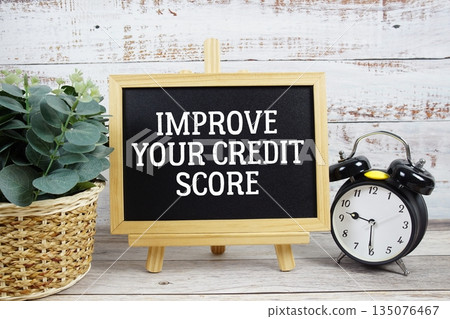 Improve Your Credit Score text written on blackboard with alarm clock on wooden background 135076467