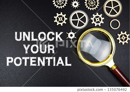 Unlock Your Potential text message with magnifying glass on black background 135076492