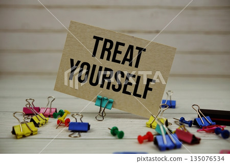 Treat Yourself text on paper card with stationary on wooden background Treat Yourself text on paper card with stationary on wooden background 135076534