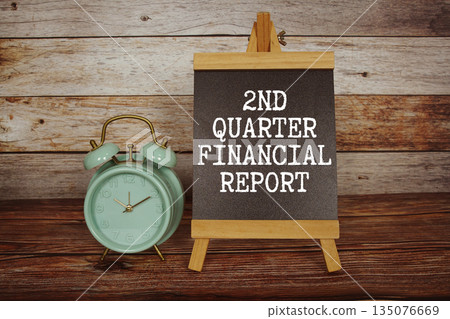 2nd Quarter Financial Report text on easel blackboard with alarm clock on wooden background 135076669