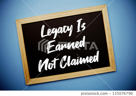 Legacy Is Earned Not Claimed text written on chalkboard flat lay on blue background Legacy Is Earned Not Claimed text written on chalkboard flat lay on blue background 135076790