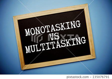 Monotasking Vs Multitasking text written on chalkboard flat lay on blue background Monotasking Vs Multitasking text written on chalkboard flat lay on blue background 135076791