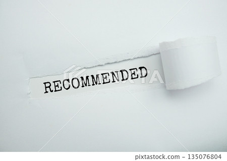 Recommended message written on white paper with torn paper background 135076804